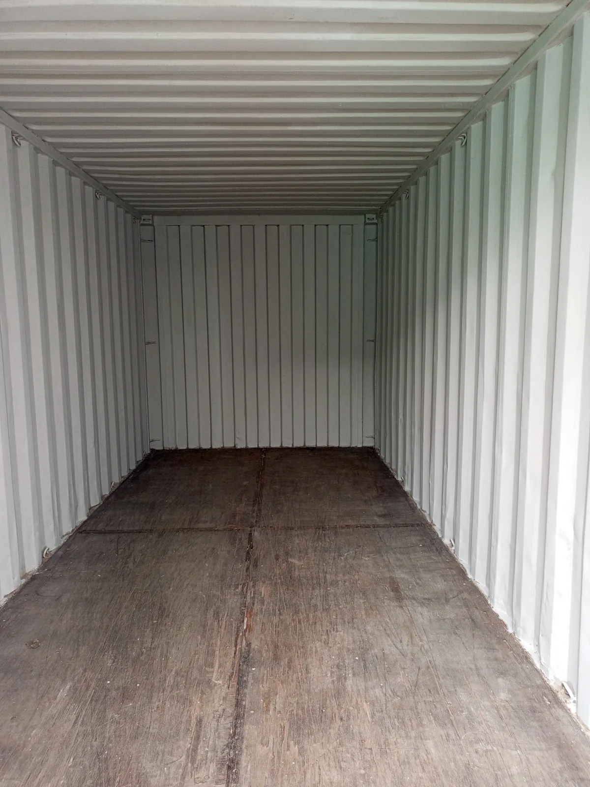 Shipping container interior with clean corrugated walls and timber floor